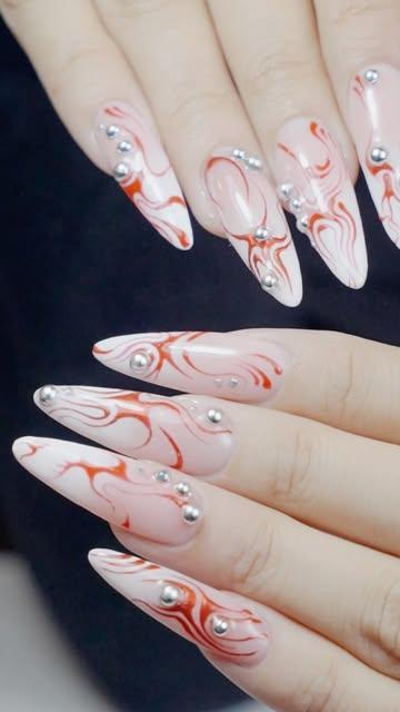 Uñas largas blancas con líneas rojas y piedras