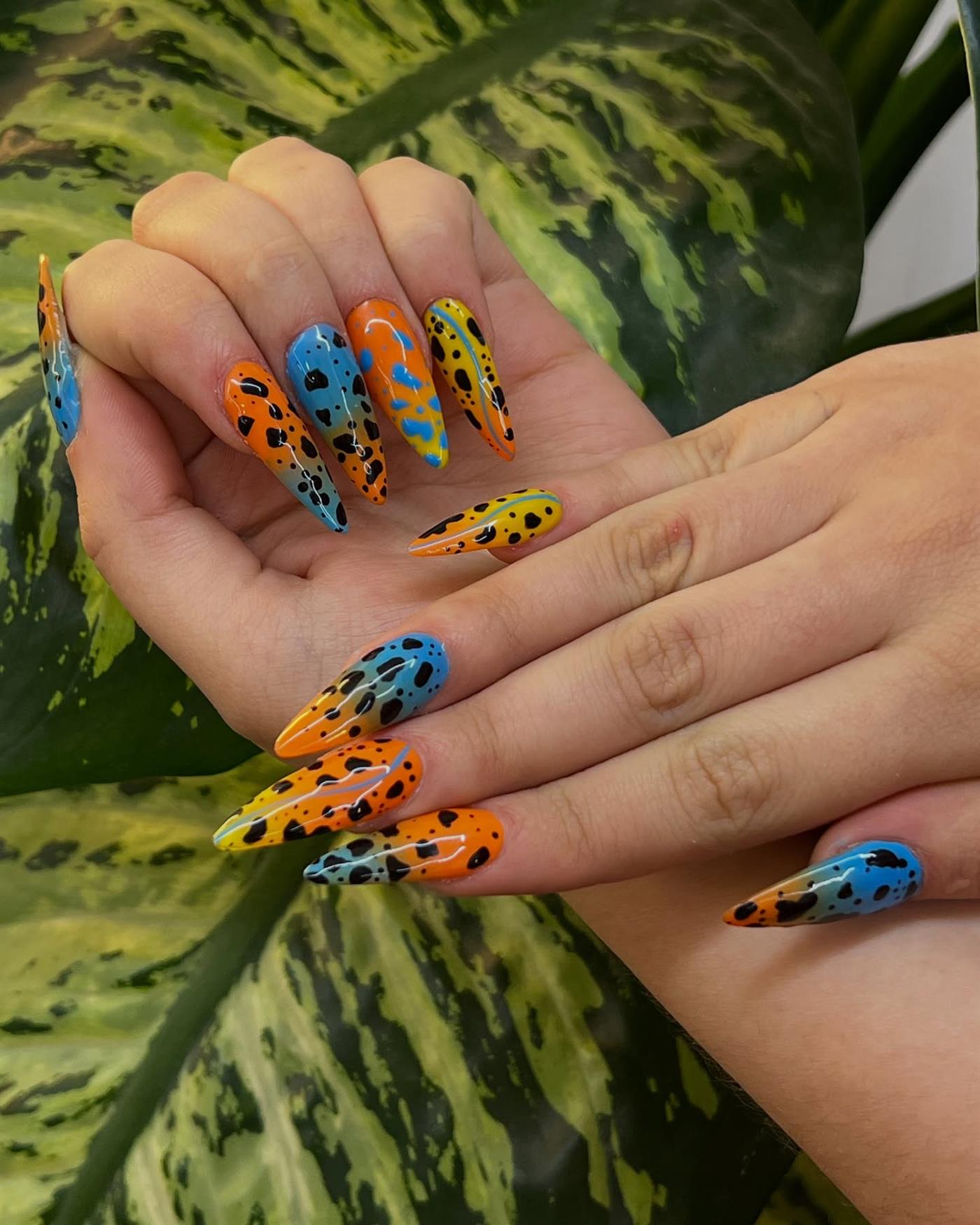 Uñas largas naranja y azul con manchas de rana
